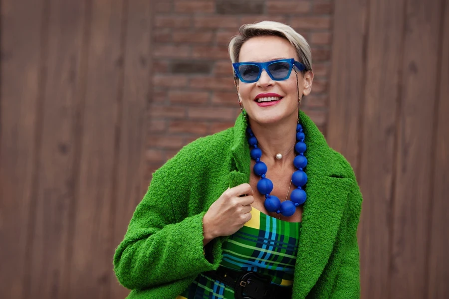 Mulher madura vestindo uma jaqueta verde brilhante e vestido combinando