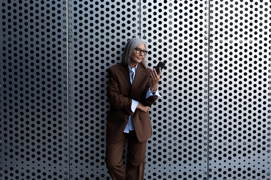 Mujer madura con elegantes pantalones, traje y camisa marrones