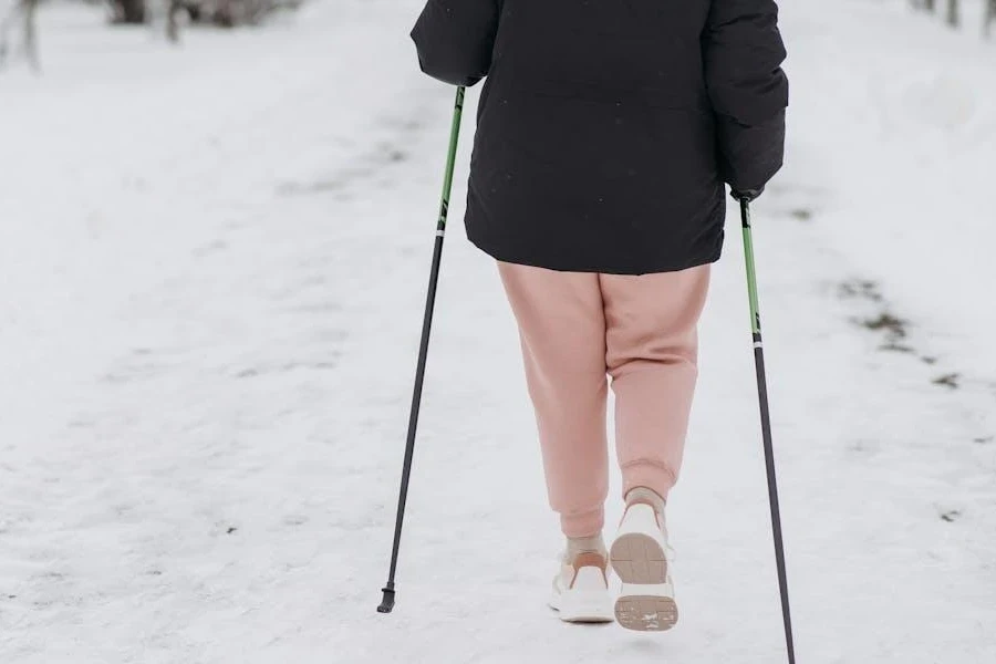 Persona che cammina nella neve con bastoncini da trekking