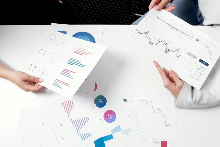 Persons Holding Printer Papers with Graphs