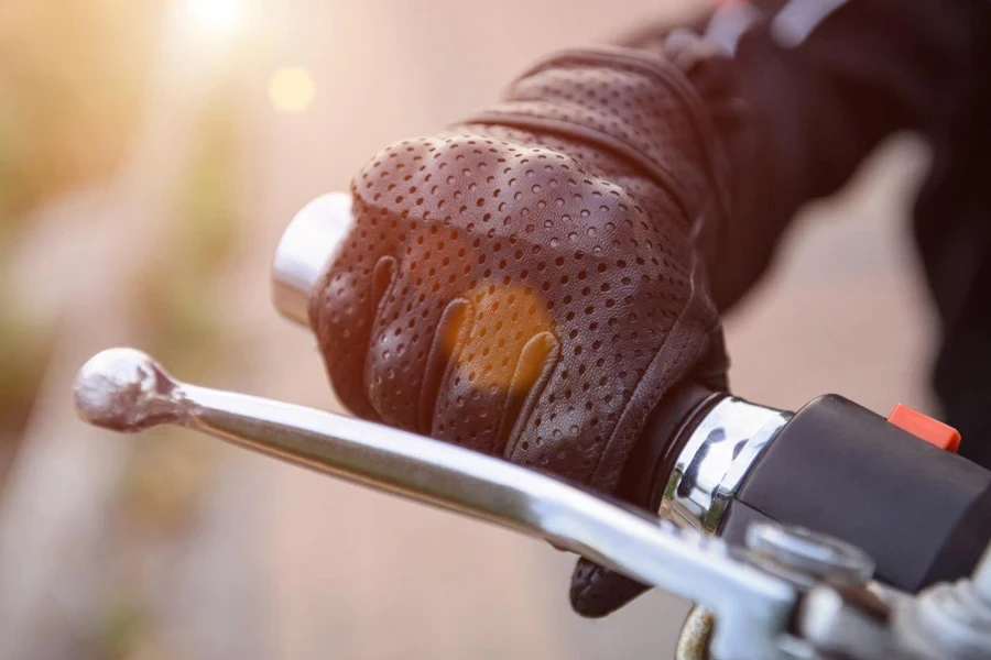 Luvas protetoras de motociclista em uma roda de motocicleta