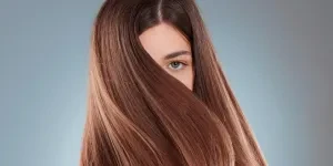 Fotografía de estudio de una hermosa mujer joven mostrando su largo cabello castaño.