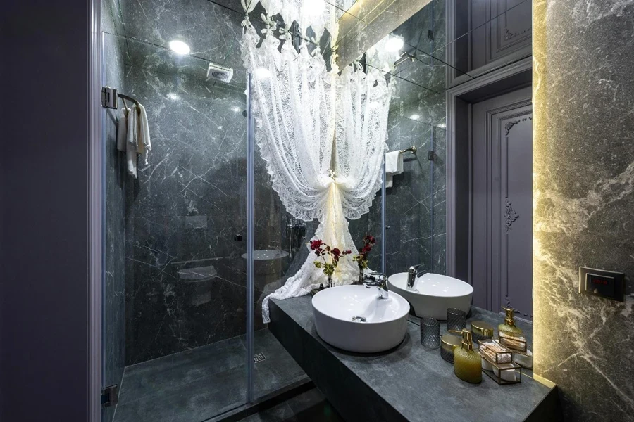 Tulle curtain between shower room and washbasin with various toiletry products reflecting in mirror at home