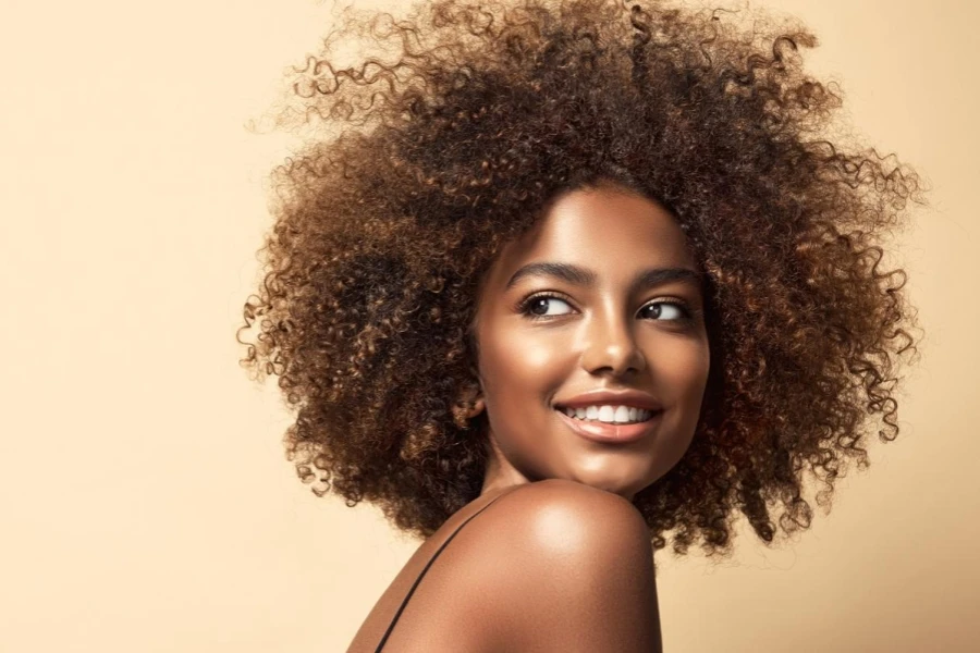 Un large sourire aux dents blanches et une expression de plaisir sur le visage d'une jeune femme à la peau brune