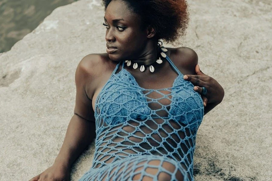 Femme posant dans un bikini bleu et une robe en maille