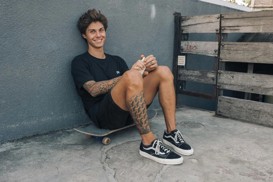 Young Man Wearing Shorts Sitting on Skateboard