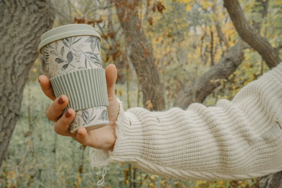 a person holding a coffee cup in their hand