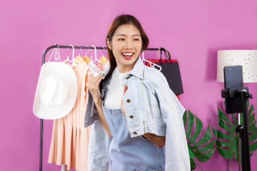 a woman showing viewers how to style a jacket on livestream