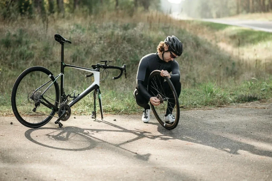 Ciclista che cerca di riparare il pneumatico