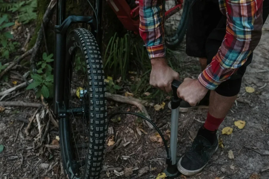 自転車のタイヤに空気を入れる男性