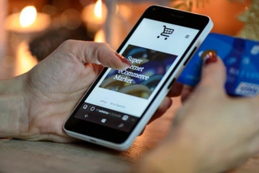 woman holding a phone and a credit card