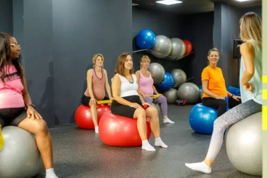 Donne che usano la palla per l'equilibrio durante la gravidanza durante la lezione di ginnastica