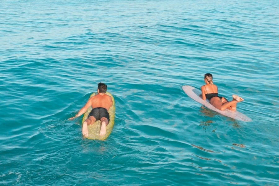 Una coppia che usa la tavola da surf sulla spiaggia