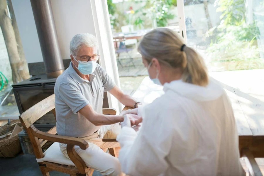 Un médecin effectue un examen médical sur un homme âgé à domicile