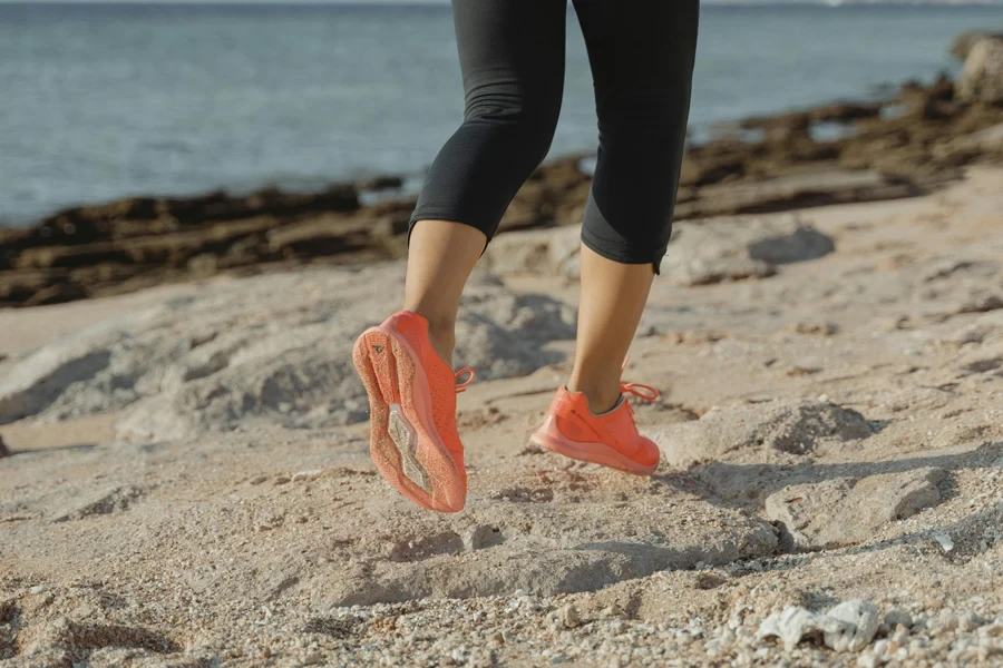 Uma mulher de legging preta e sapatos laranja