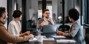 Un mentor enfocado explica el proyecto a los aprendices en la sala de juntas de la empresa.