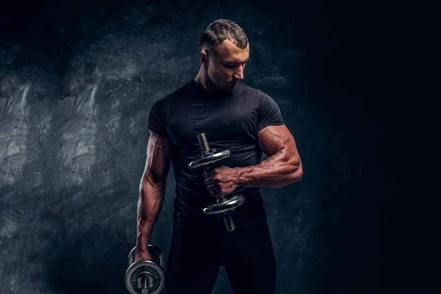 Un hombre musculoso que viste una camiseta de rendimiento y levanta una barra.