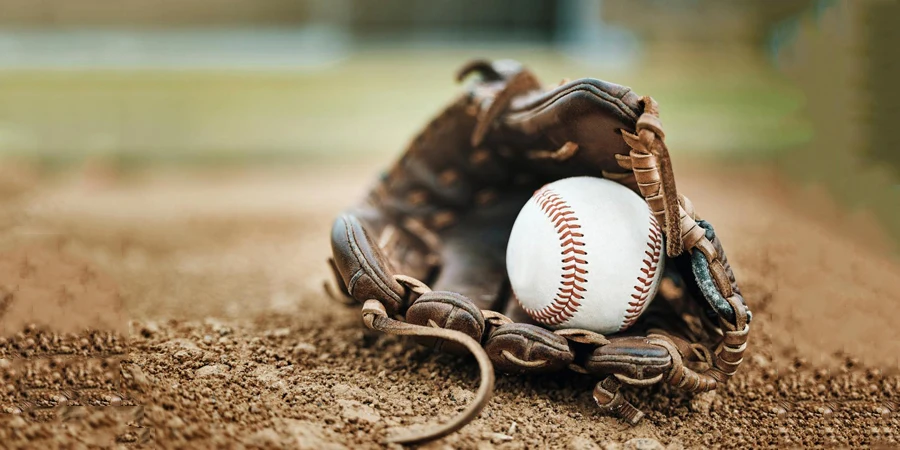 Baseball, leather glove and ball on pitch sand after fitness, workout or training for match or competition