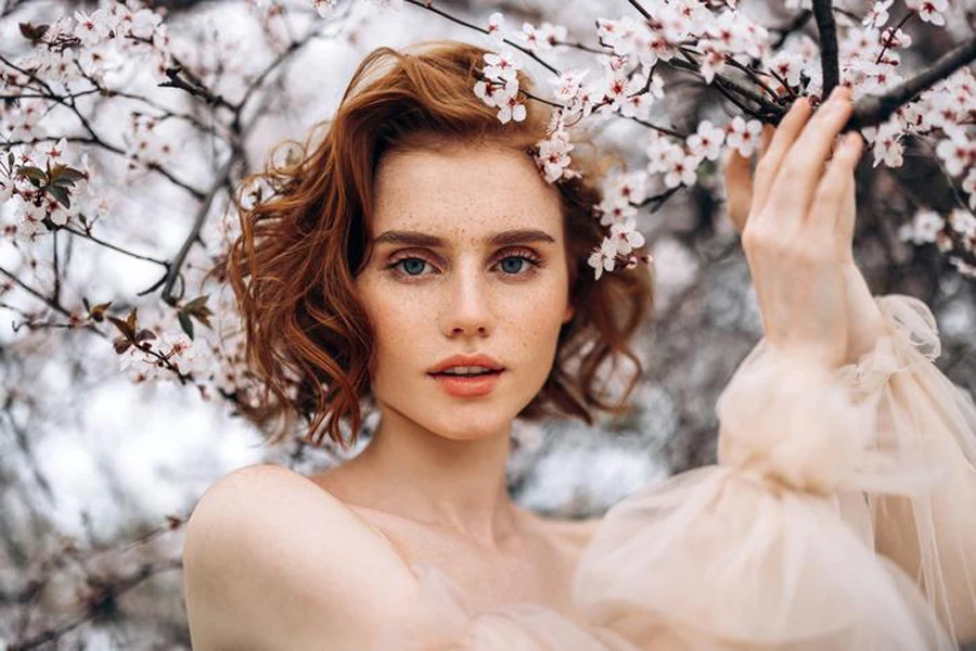 Beautiful girl on the background of the spring bush