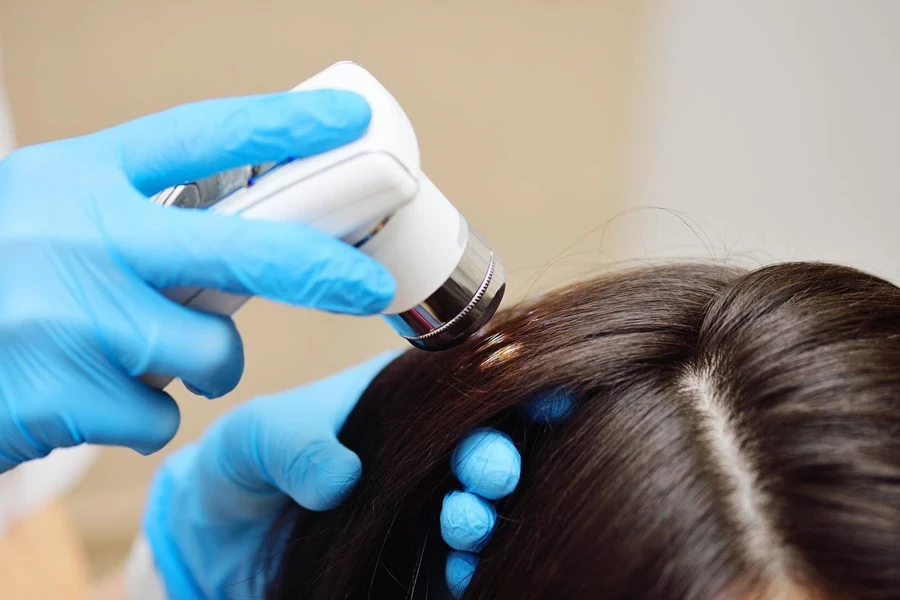 Close-up of trichologist diagnoses the condition of the patient's hair