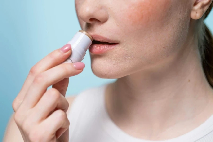 Crop Photo Of Woman Using A Lip Balm