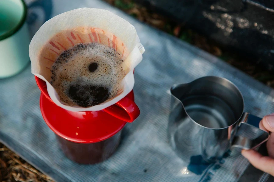 布地の上のカラフェでコーヒーを淹れる農作物ハイカー