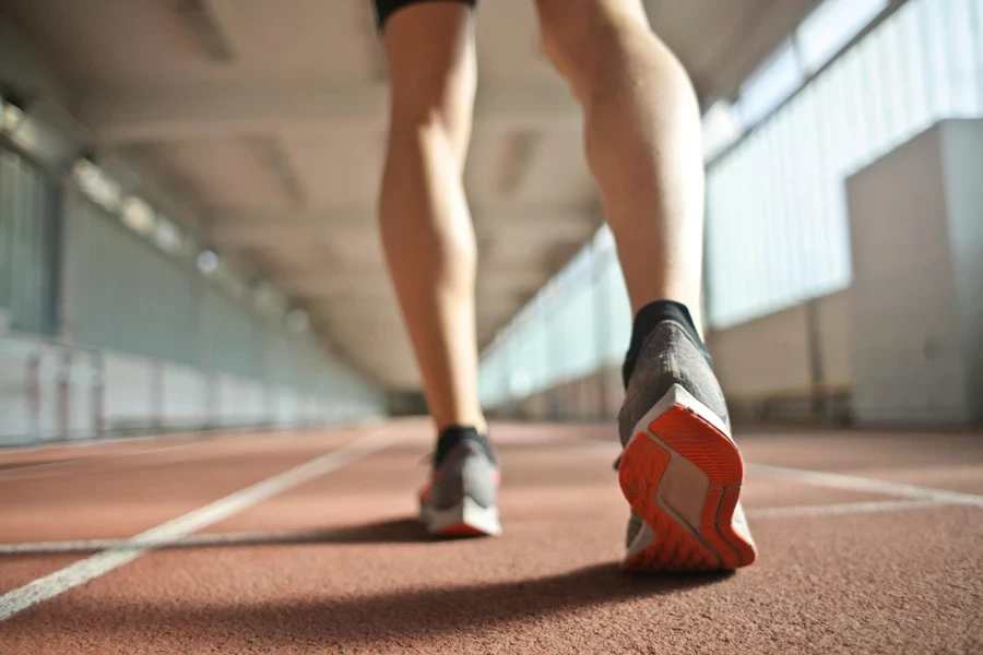 Corredor em forma em pé na pista de corrida na arena de atletismo