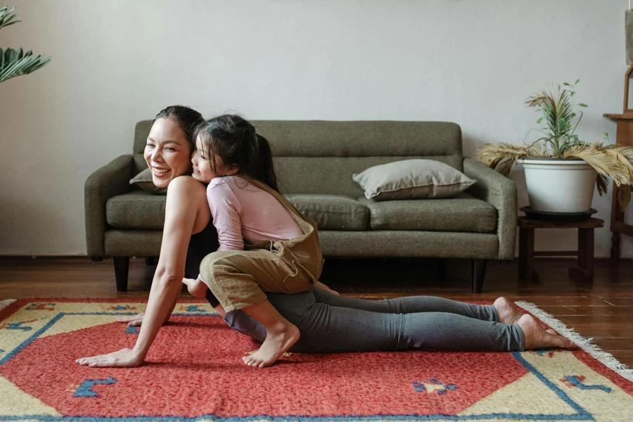 Mädchen umarmt ihre Mutter während der Yoga-Pose