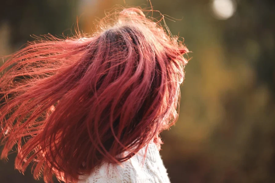 Girl with long red hair fluttering in the wind