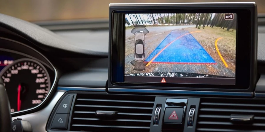 Interior de carro premium com câmera de ré, trajetória dinâmica, linhas de curva e assistente de estacionamento, volante virado para a direita