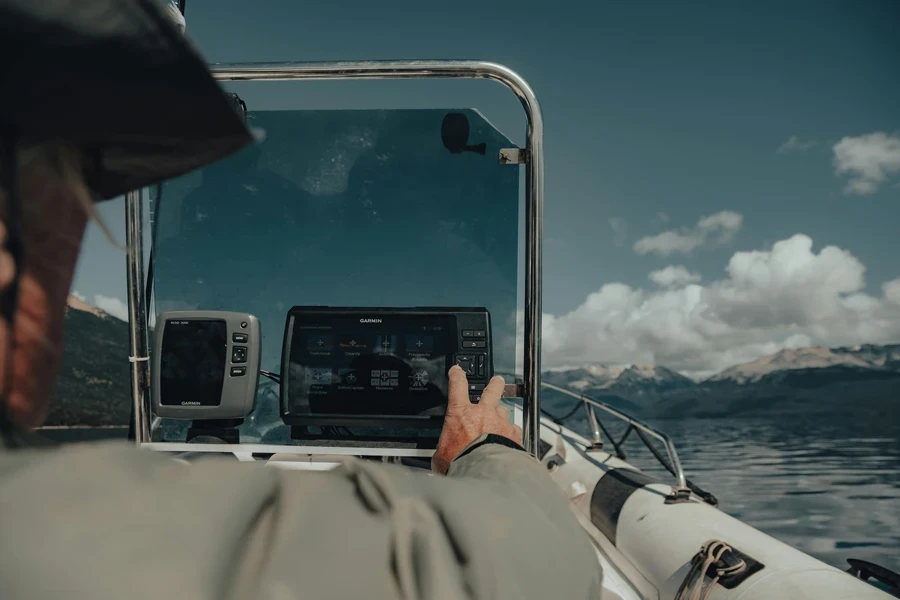 Hombre tocando un dispositivo electrónico en un barco