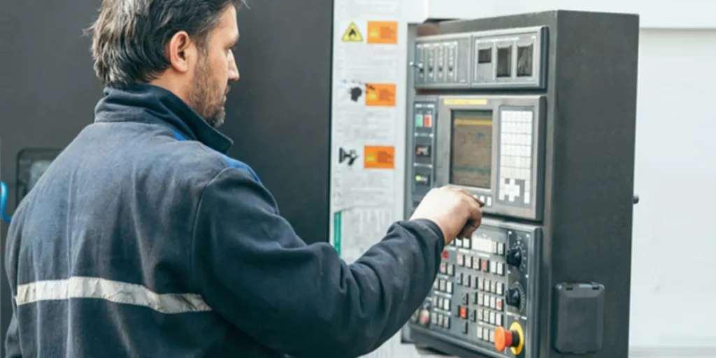 Homme utilisant une machine à commande programmable