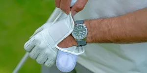 Mann zieht einen Golfhandschuh an