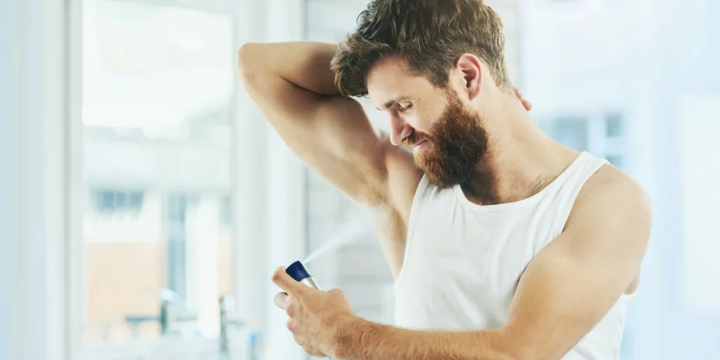 Homme utilisant un spray déodorant