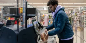 Uomo che utilizza il servizio di self-checkout in un negozio