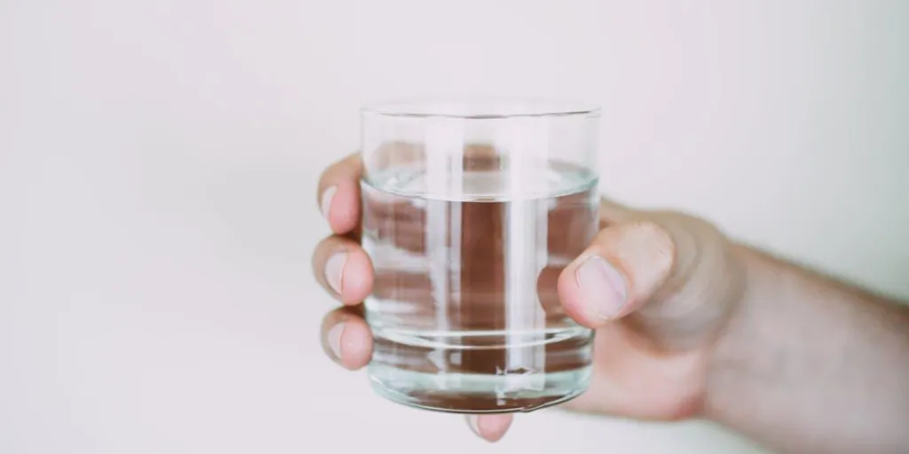 Persona sosteniendo un vaso para beber