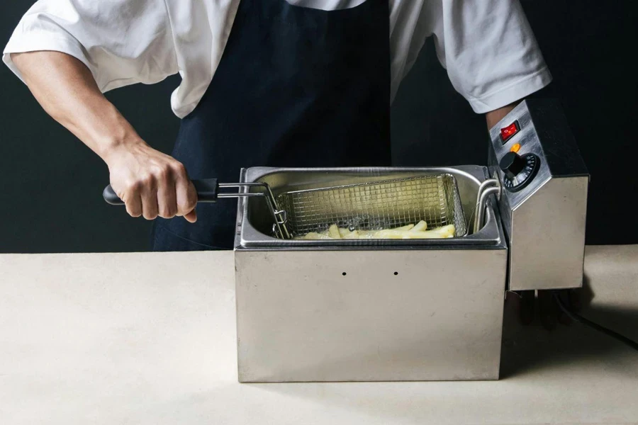 Photo of a Man in a White Shirt Frying French Fries