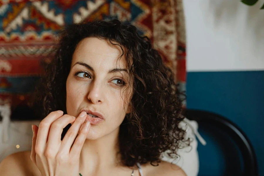 Portrait Of a Woman Applying a Lip Balm