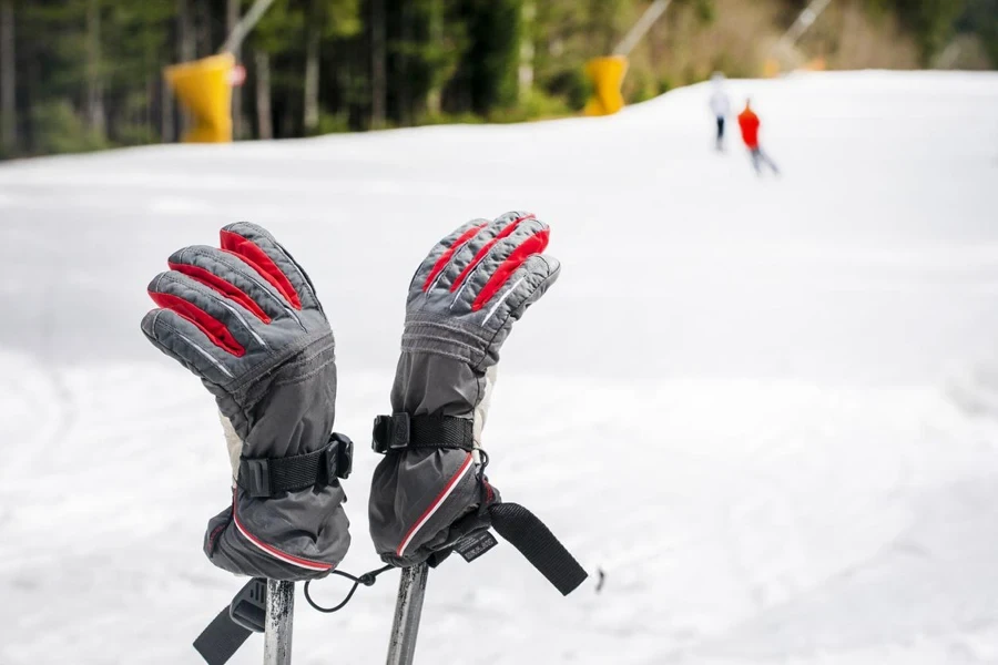 Skihandschuhe an Skistöcken auf der Piste