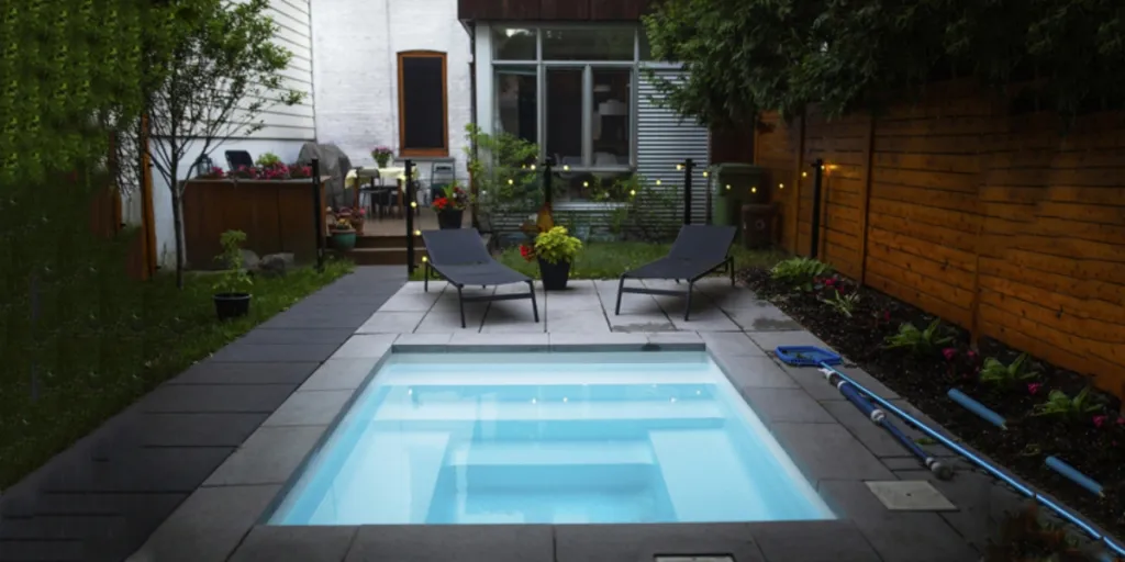 Pequeña y elegante piscina de inmersión al aire libre con varios escalones.