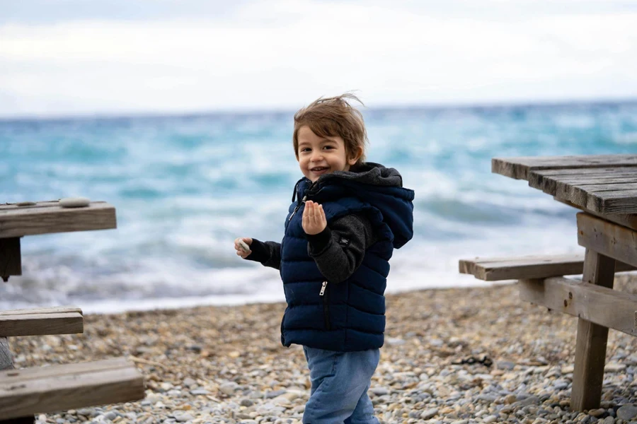 Niño sonriente en la orilla del mar