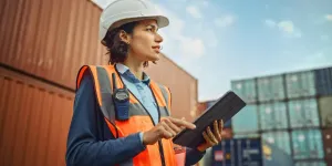 Retrato sonriente de una bella ingeniera industrial latina con casco blanco