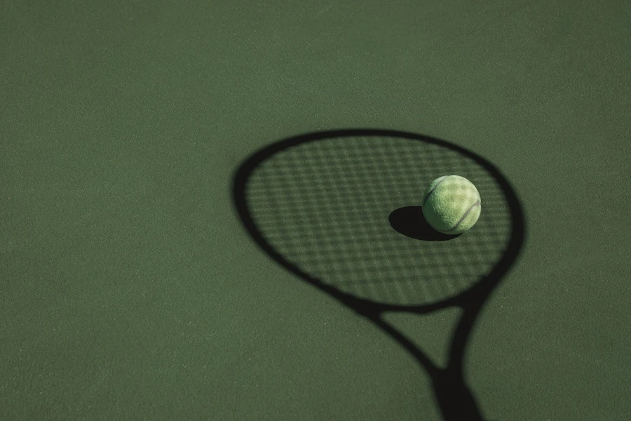 La pallina da tennis è nell'ombra proiettata da una racchetta da tennis