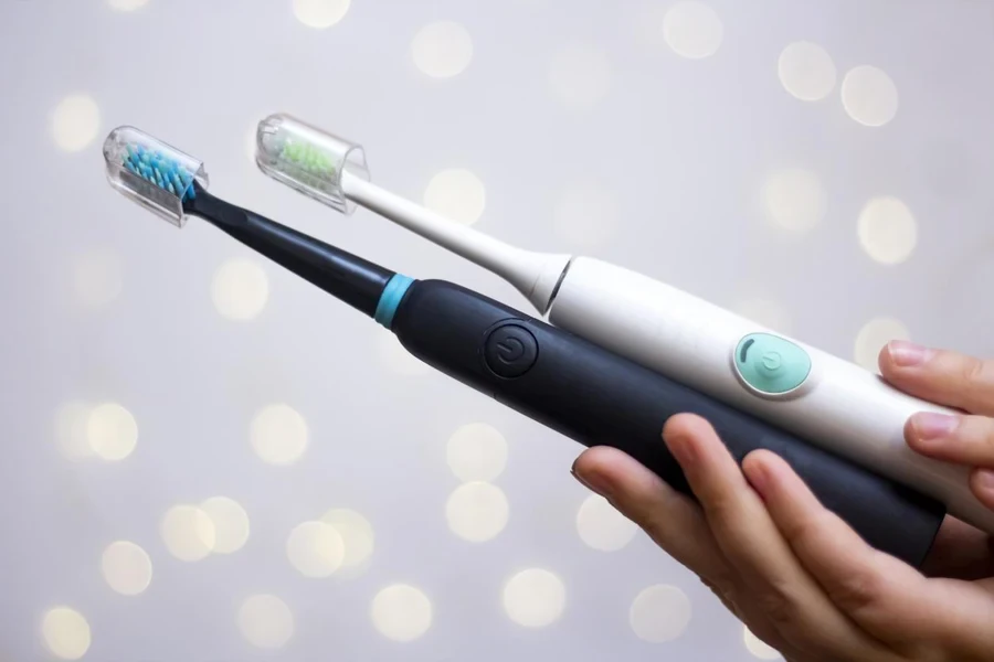 Two Electric Toothbrushes in Hands