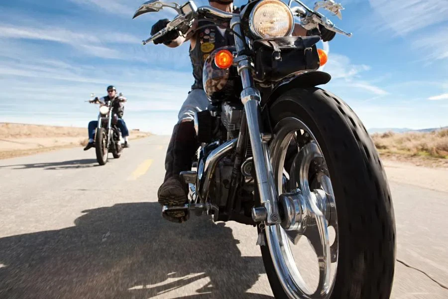 Dos hombres viajando en motocicleta por la carretera