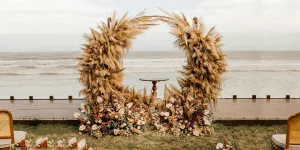 Arco de casamento com flores e decoração de palha