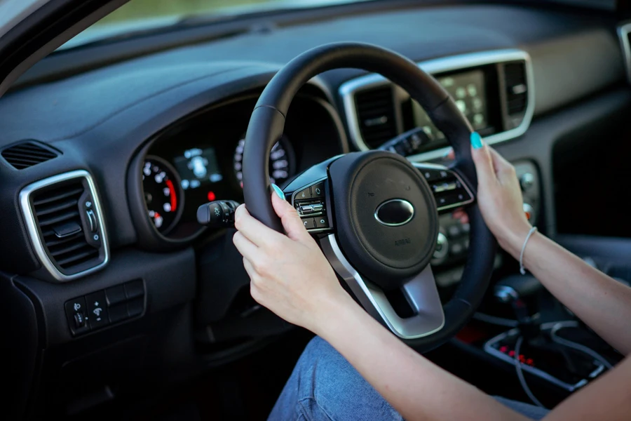 Manos de mujer sosteniendo el volante