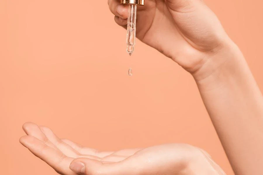 Woman holding a white and gold skincare dropper