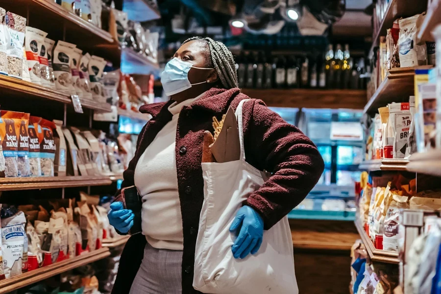 Donna che fa la spesa di beni di largo consumo confezionati in un supermercato