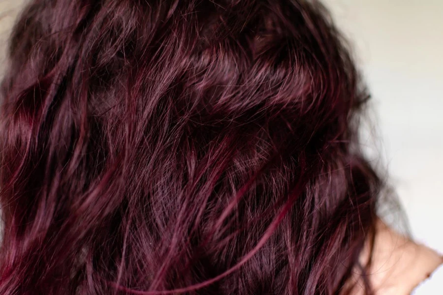 Woman with dark red hair, treatment with natural dyes based on blackberries and cherries